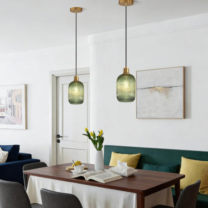 Modern dining room with green pendant lights, a wooden table, and decorative elements.