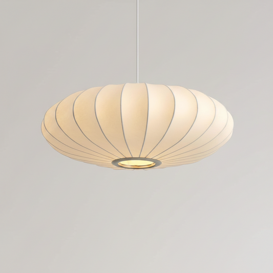 A modern pendant light with a wide, shallow, saucer-shaped shade made of pleated cream-colored fabric or paper, suspended by a thin white cord against a neutral light gray background.