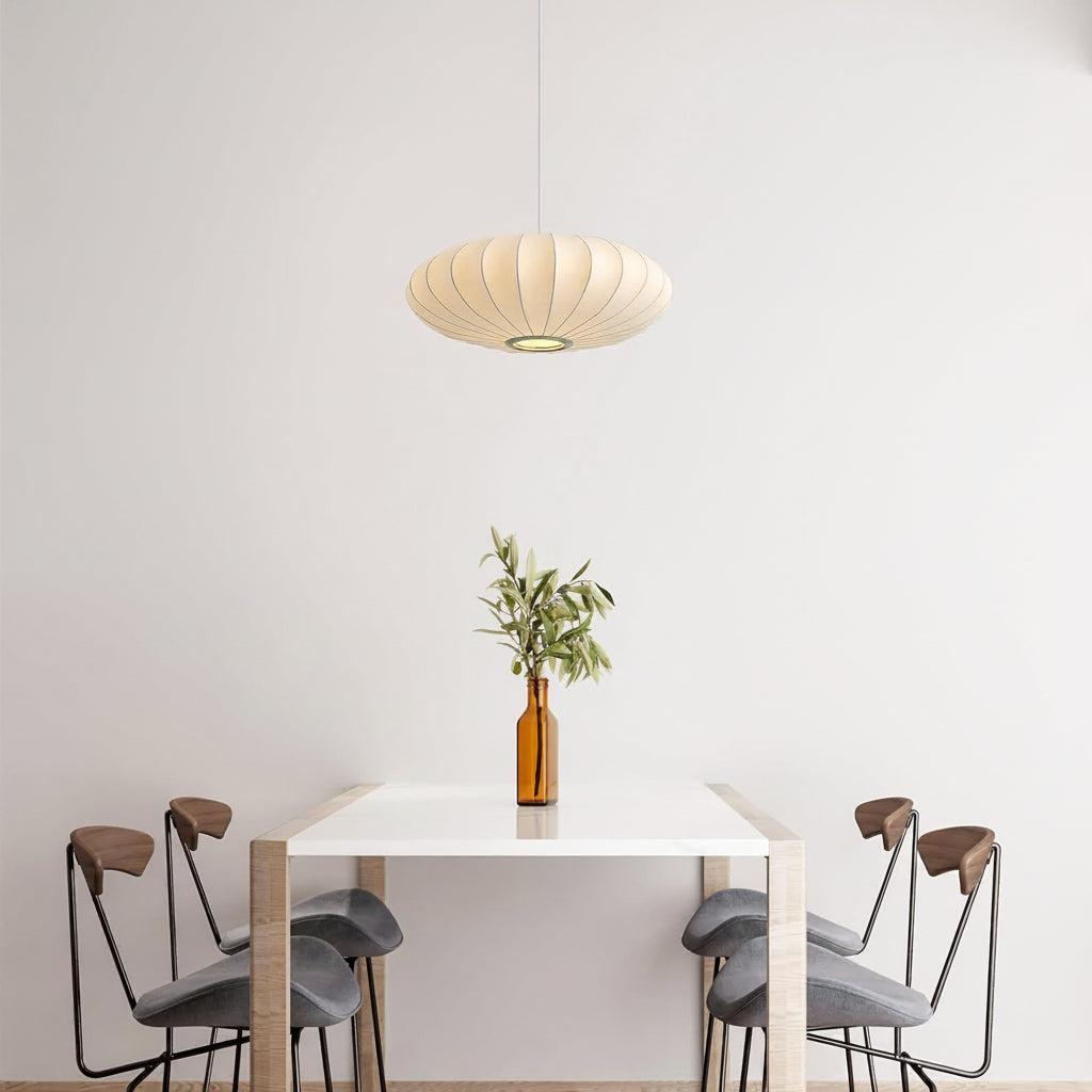 Modern dining area with a white table, gray stools, and a hanging lamp.
