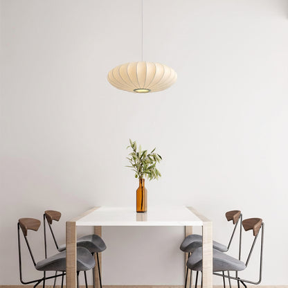 Modern dining area with a white table, gray stools, and a hanging lamp.