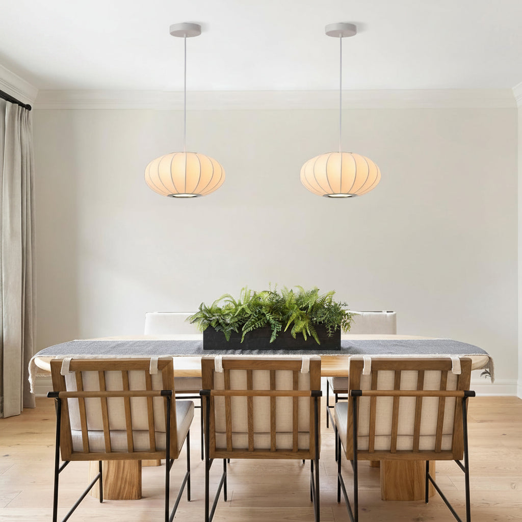 Dining room with a table, chairs, and pendant lights.