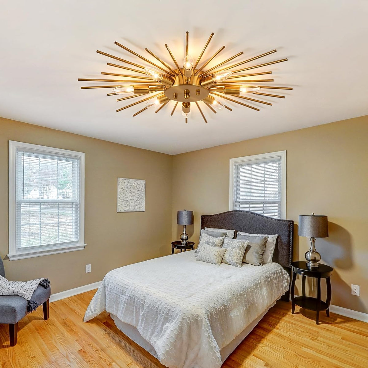 Modern bedroom with a gold ceiling light fixture, bed, and side tables.