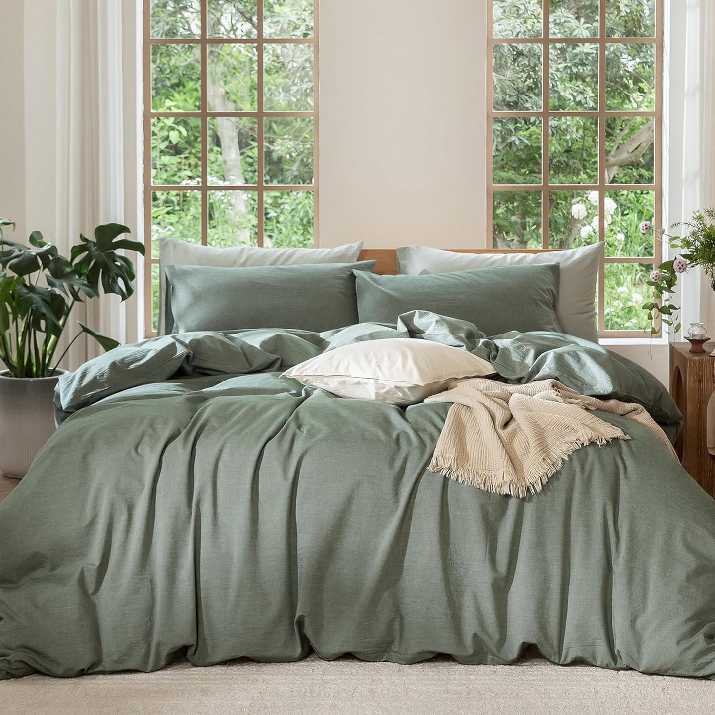 Green bedding set on a bed with a window in the background