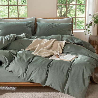 Green bedding set on a bed with a window in the background
