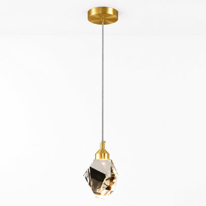 A modern pendant light with a brushed gold ceiling canopy and socket, a slim gray cord, and a faceted clear crystal shade, shown against a plain white background.