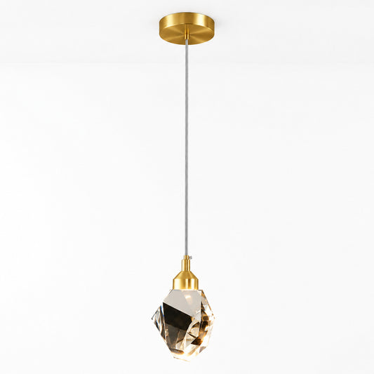 A modern pendant light with a brushed gold ceiling canopy and socket, a slim gray cord, and a faceted clear crystal shade, shown against a plain white background.