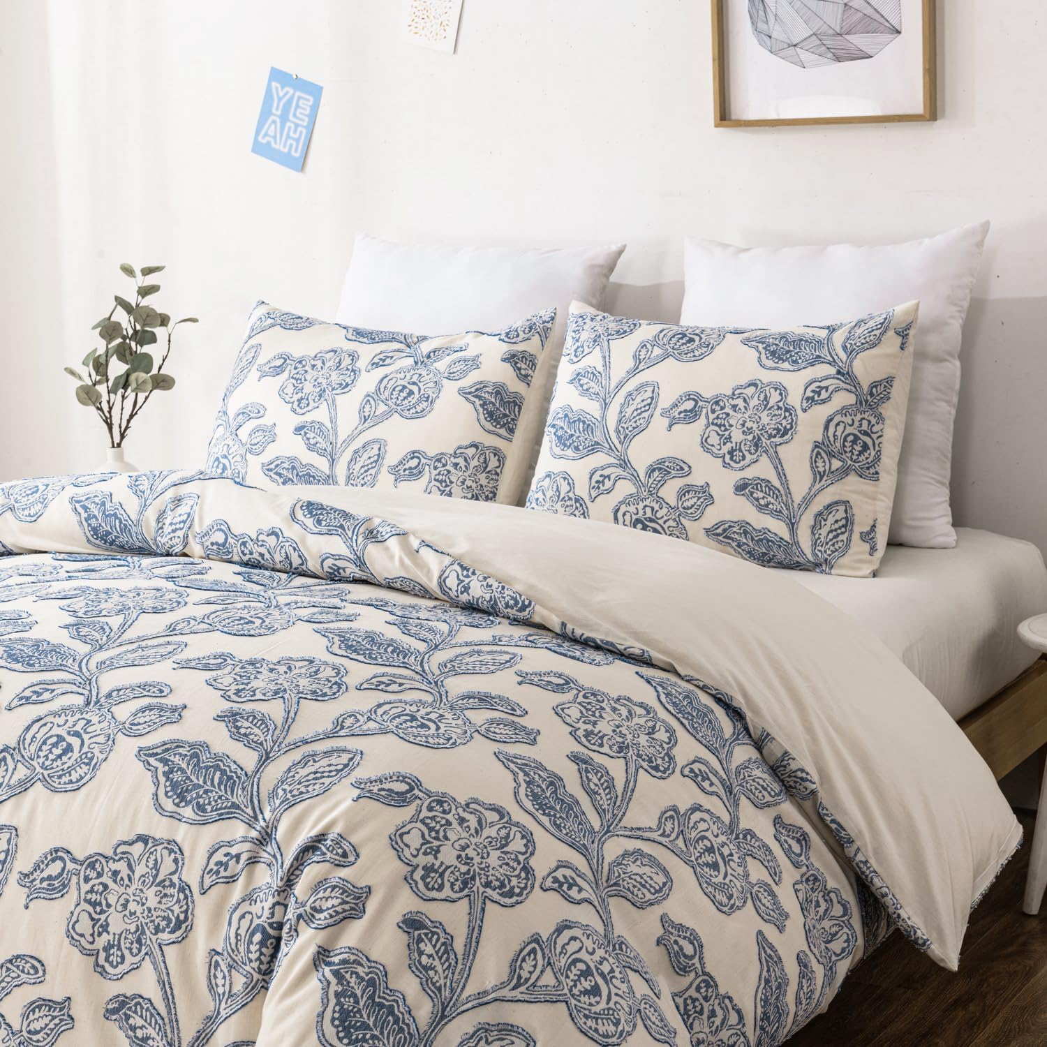 Bed with blue floral patterned bedding and pillows in a room setting.