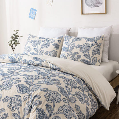 Bed with blue floral patterned bedding and pillows in a room setting.