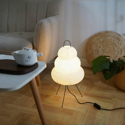 Modern lamp on a wooden floor with a sofa and side table in the background