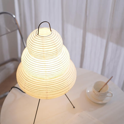 Woven lamp on a table with a cup and saucer in the background