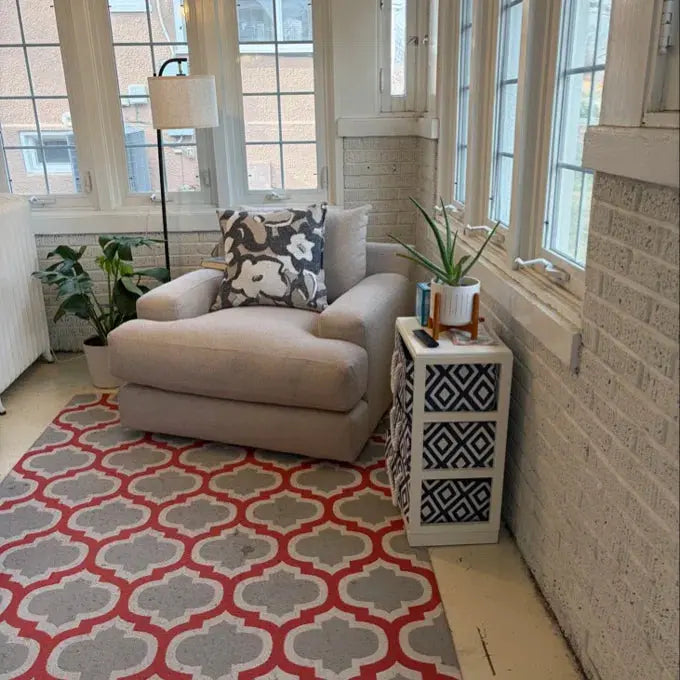 Living room with a beige armchair, patterned rug, and decorative elements.