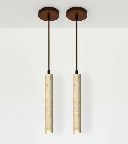 Two pendant lights with cylindrical beige shades and a dining room setting.