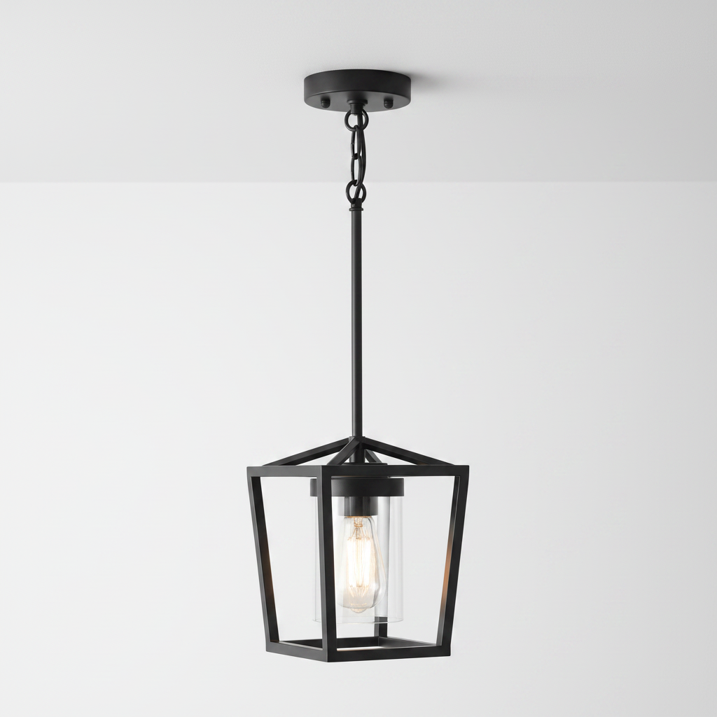 A modern black metal pendant light with a geometric open-frame lantern design and a clear glass shade showing an Edison bulb, set against a plain white background.