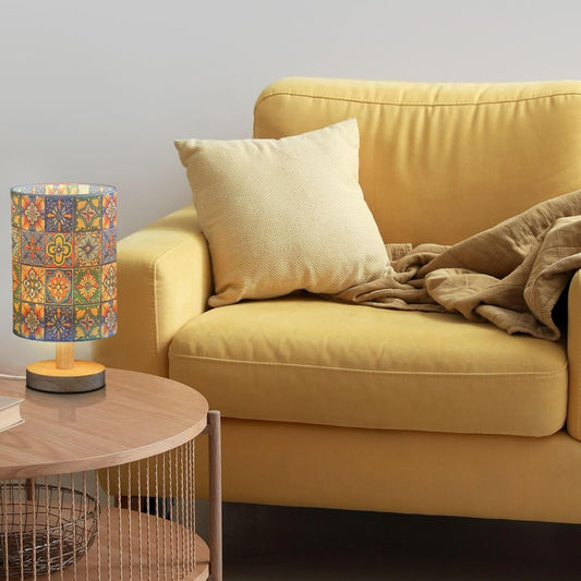 Yellow sofa with a decorative pillow and lamp in a living room setting