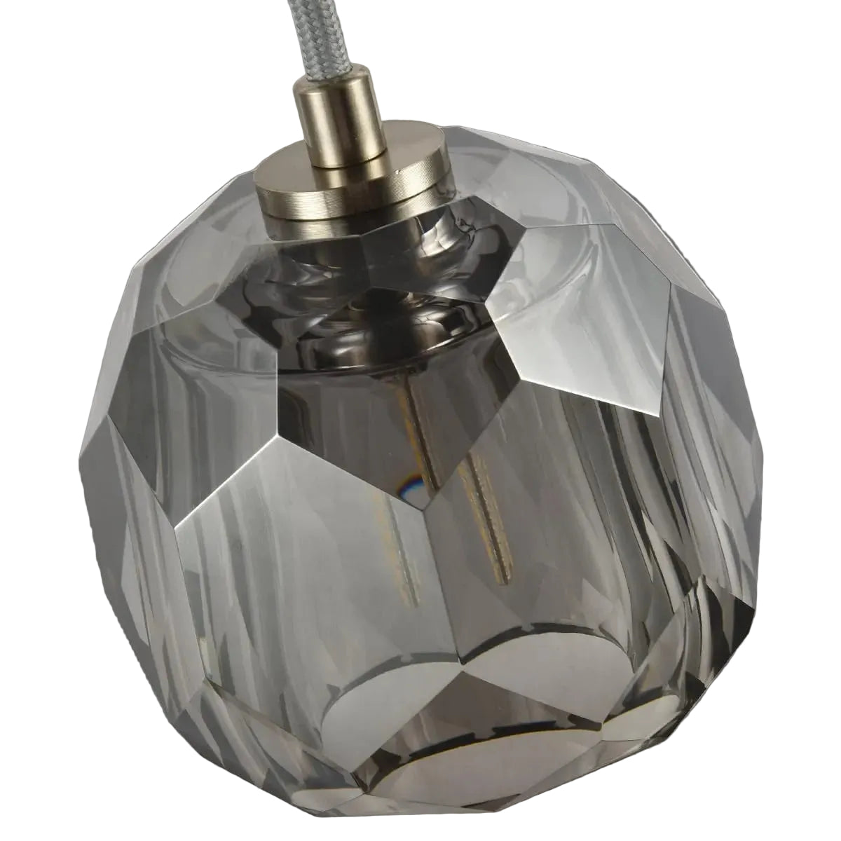 Faceted crystal lampshade with metallic base on a light gray background