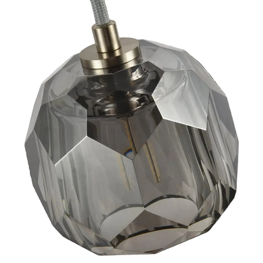Faceted crystal lampshade with metallic base on a light gray background