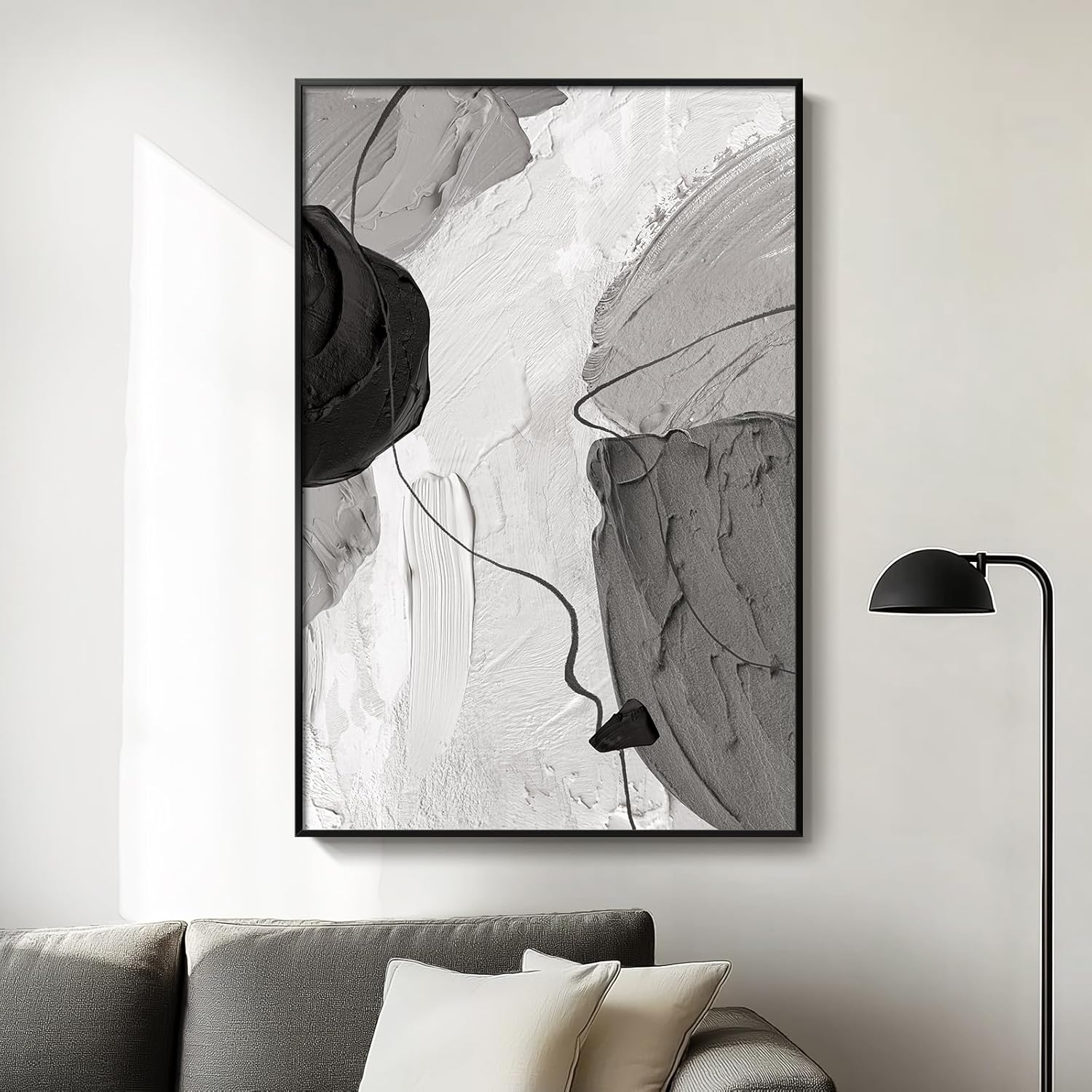 Abstract art print in a black frame on a wall above a sofa.
