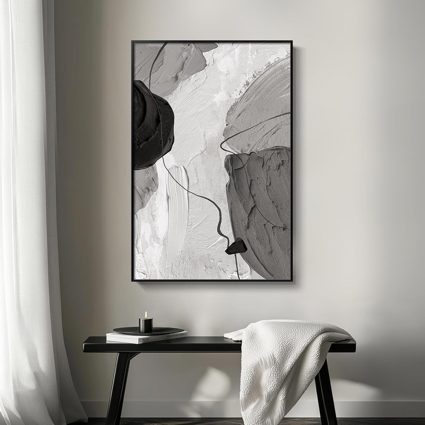 Abstract black and white painting on a wall above a bench with a white towel.