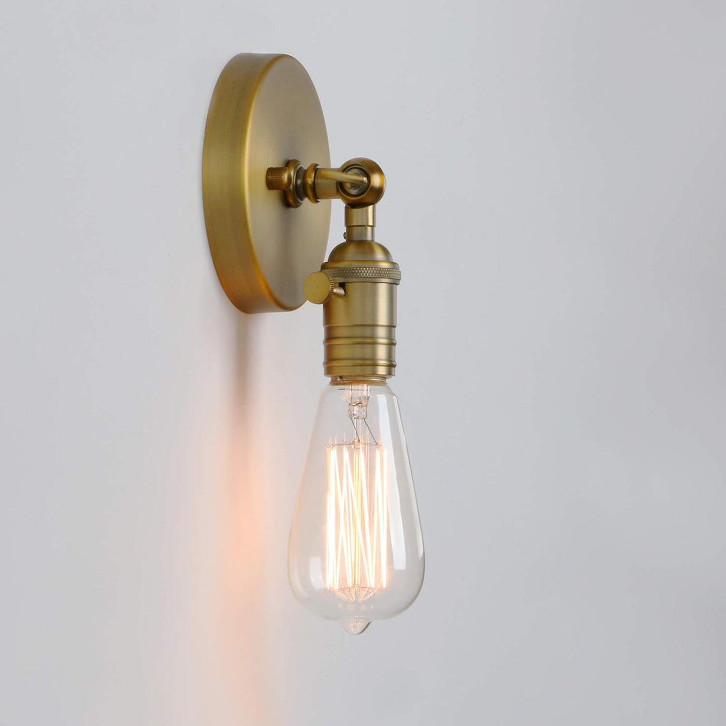 Vintage-style wall light fixture with a lit bulb on a plain background