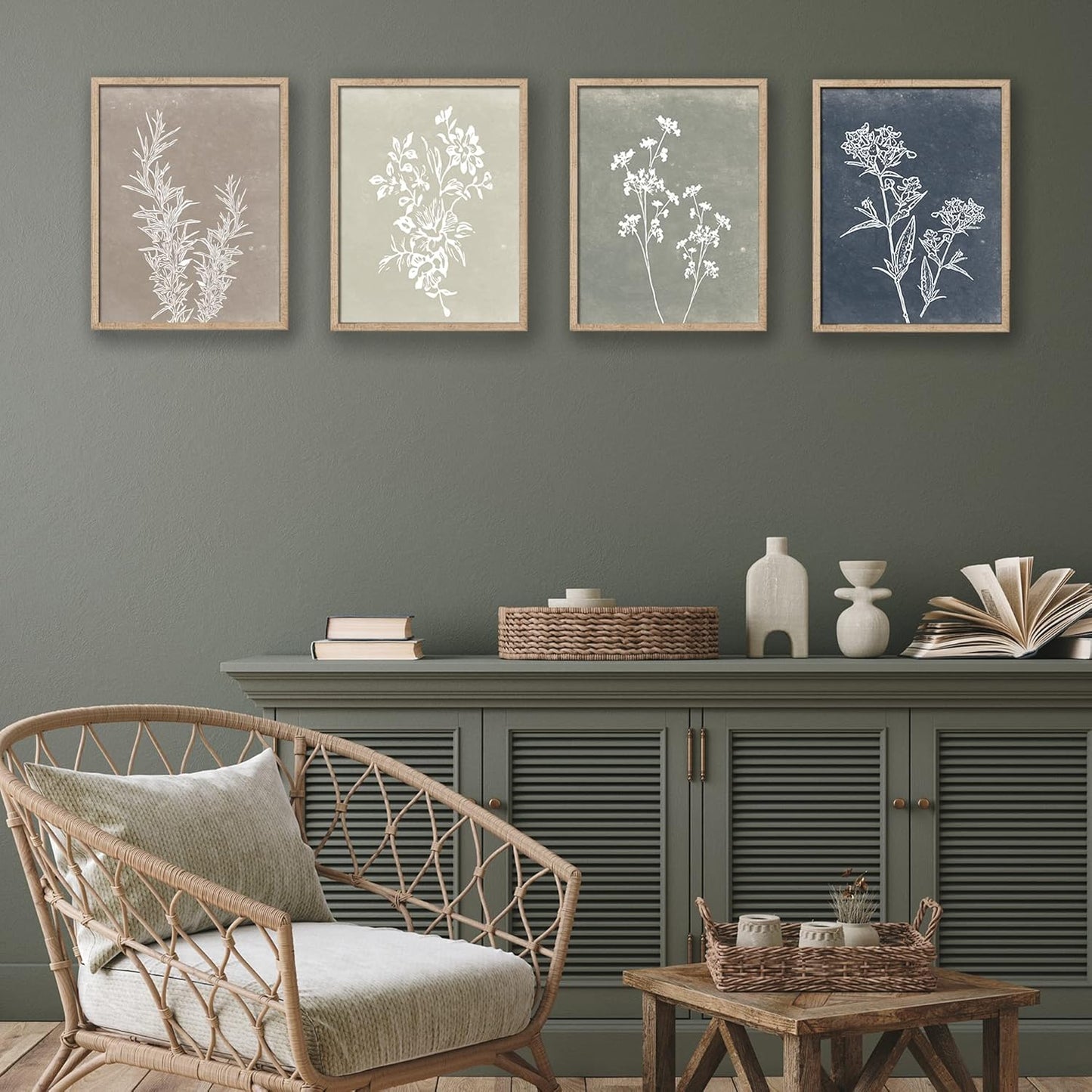 Living room with wicker chair, wooden side table, and framed botanical prints on a gray wall.