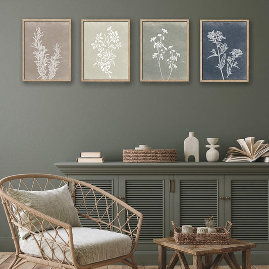 Living room with wicker chair, wooden side table, and framed botanical prints on a gray wall.