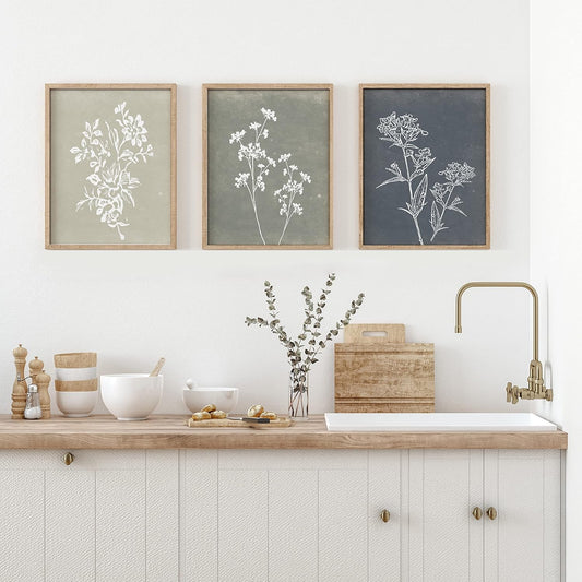 Kitchen with wooden countertop, sink, and framed botanical prints on the wall.