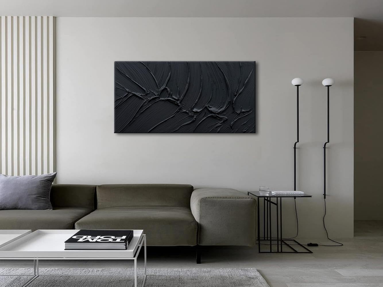 Modern living room with a gray sofa, coffee table, and abstract black wall art.
