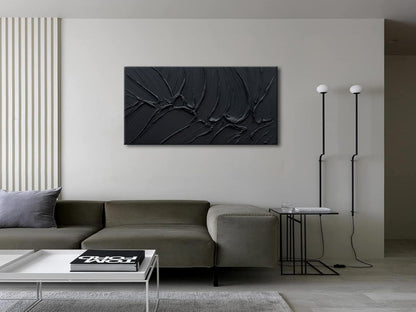 Modern living room with a gray sofa, coffee table, and abstract black wall art.