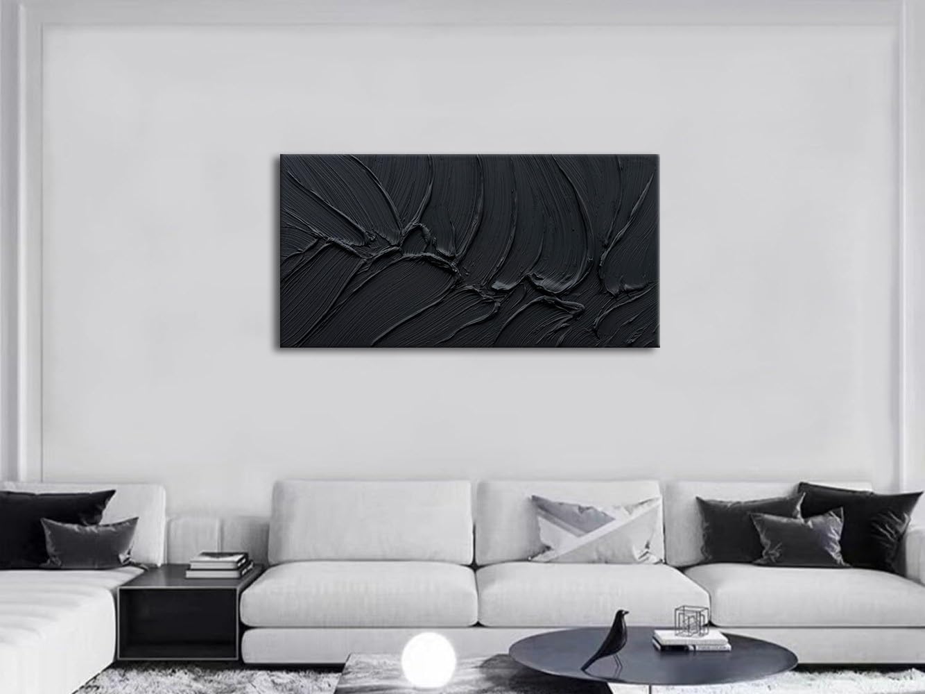 Modern living room with a black abstract wall art piece on a white wall.