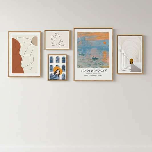 Five framed wall art prints in light wood frames hang on a light gray wall. The artwork includes abstract shapes, a white dove illustration, a Claude Monet landscape print, a stylized figure in blue and orange, and an arched corridor scene.