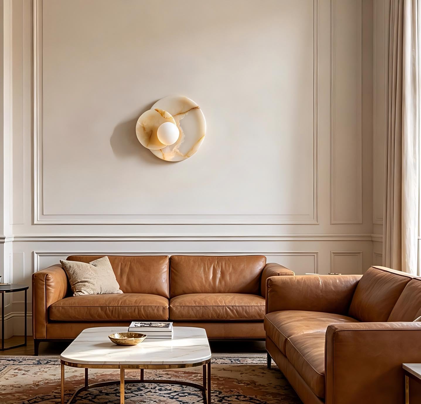 Brown leather sofa in a living room with a wall sconce and coffee table.