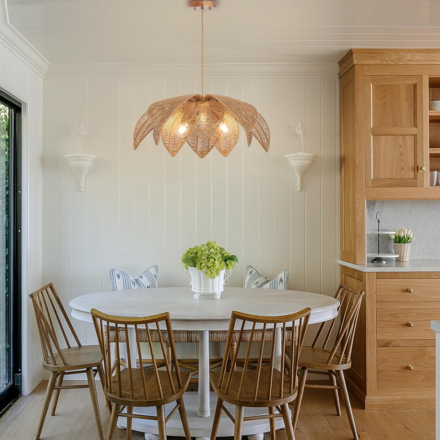 Dining room with wooden chairs, white table, and wicker pendant light.
