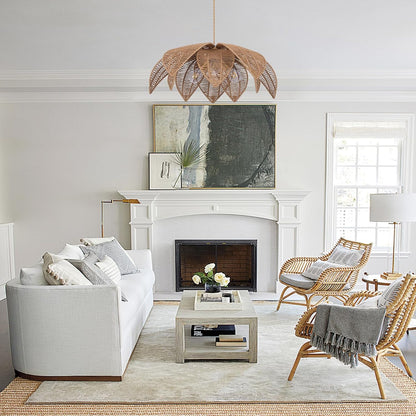 Living room with white sofa, wicker chairs, and a fireplace.