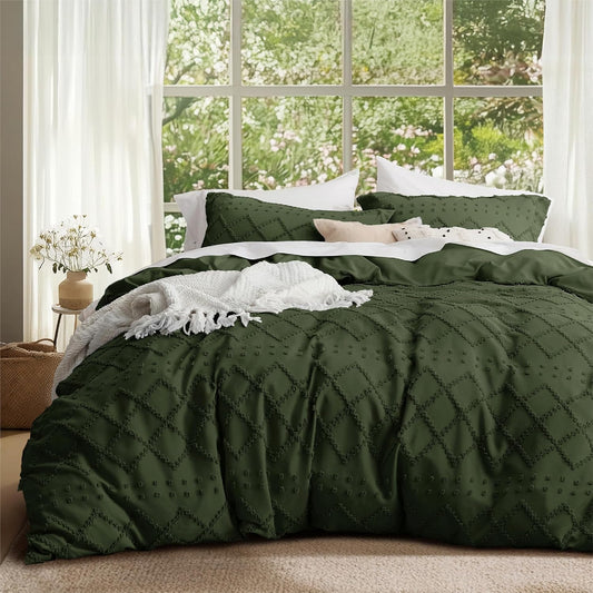 Green quilted comforter on a bed with a window view of greenery