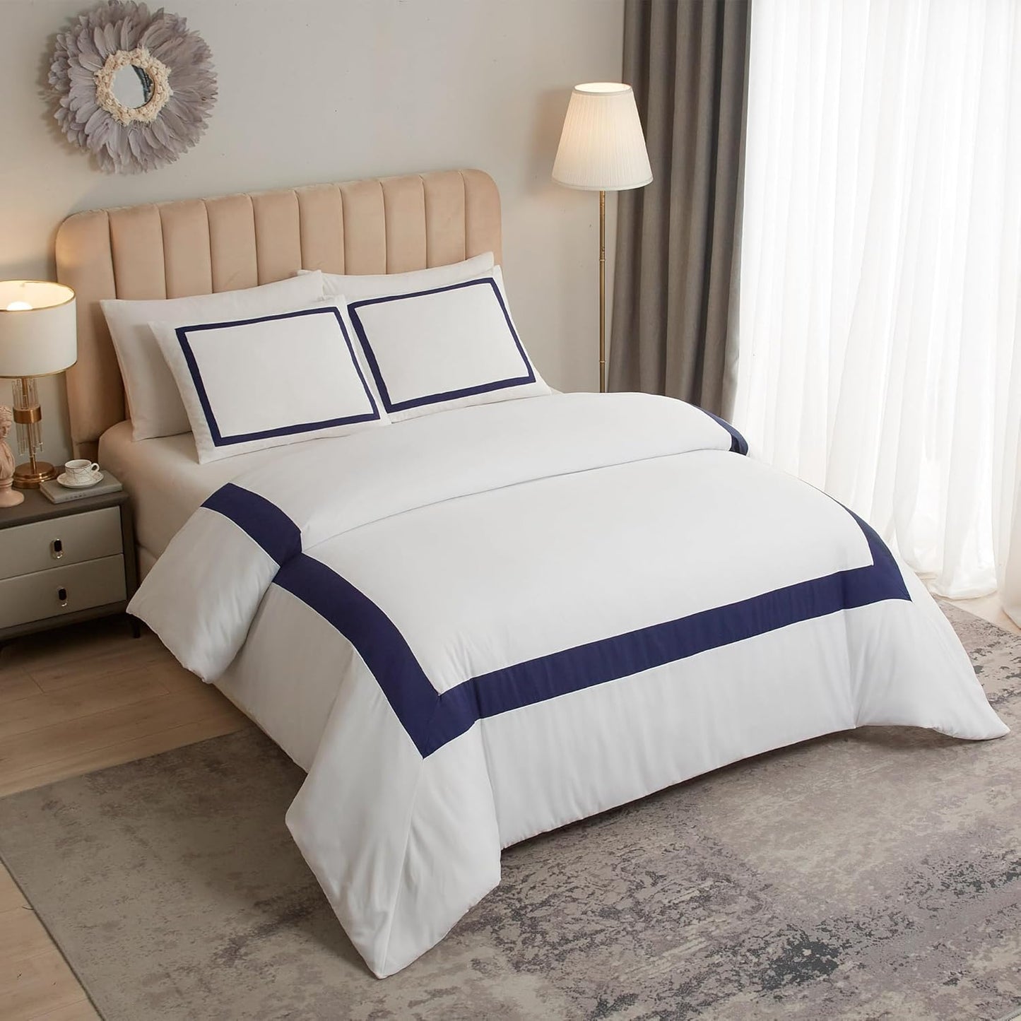 White comforter with navy border on a bed in a bedroom setting.