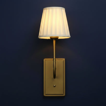Wall-mounted lamp with a white shade and gold fixture on a light gray background