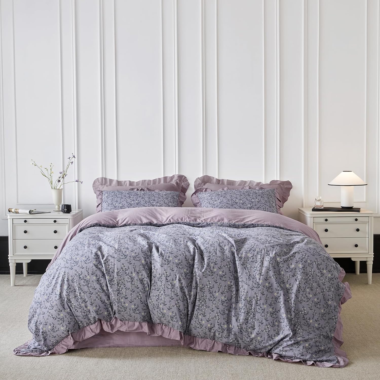 Bed with purple floral bedding in a bedroom setting