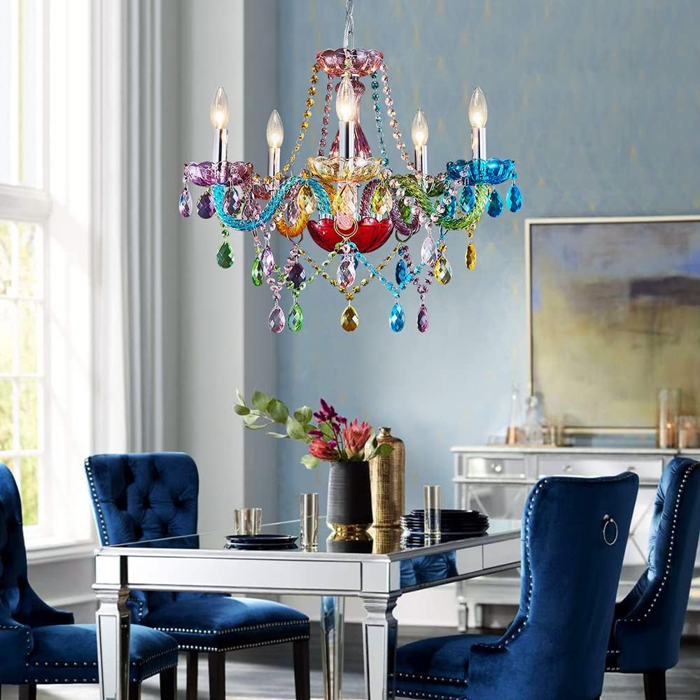 Colorful chandelier hanging above a dining table with blue chairs in a room with light blue walls.