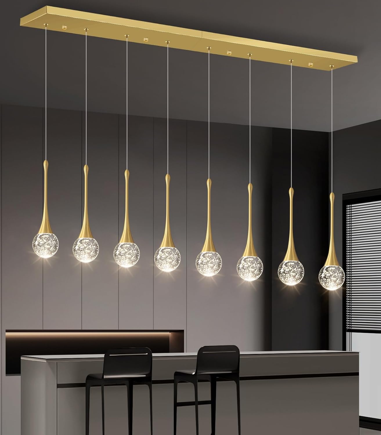 Modern pendant light fixture with gold accents and crystal-like glass shades in a room setting.