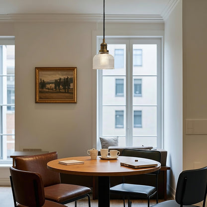 Person sitting at a table in a modern office setting with large windows.