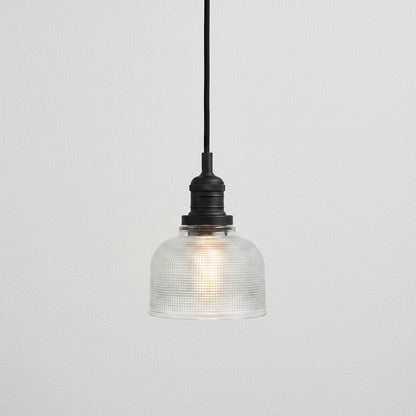 Pendant light with textured glass shade and black metal fixture on a white background
