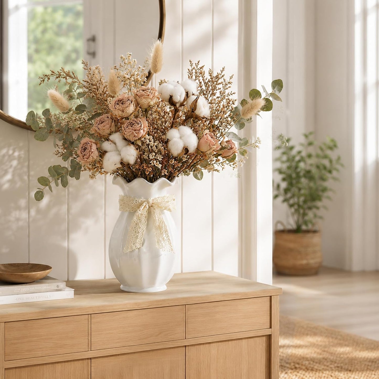 Decorative flower arrangement in a white vase on a wooden cabinet with a blurred indoor background
