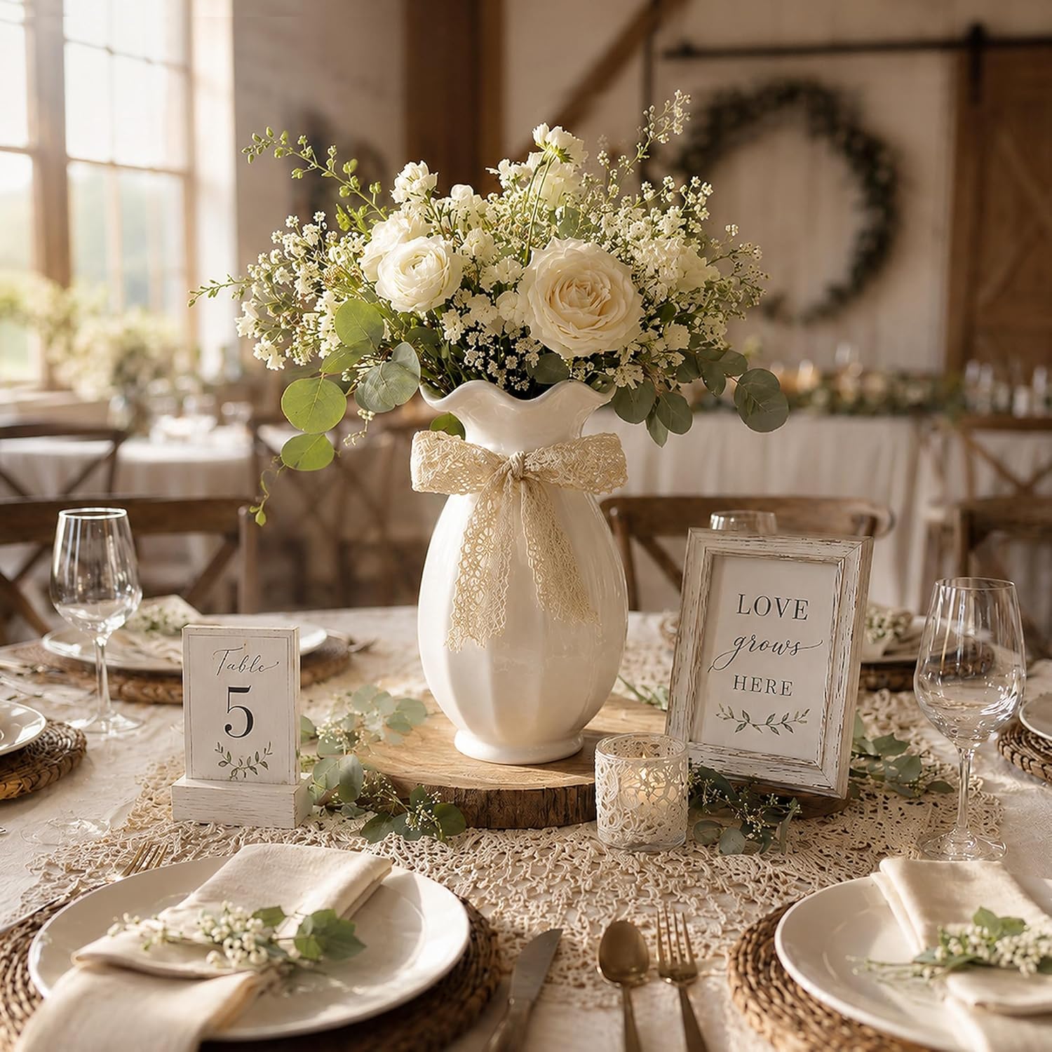 Decorative table setting with a vase of flowers and a sign on a table.