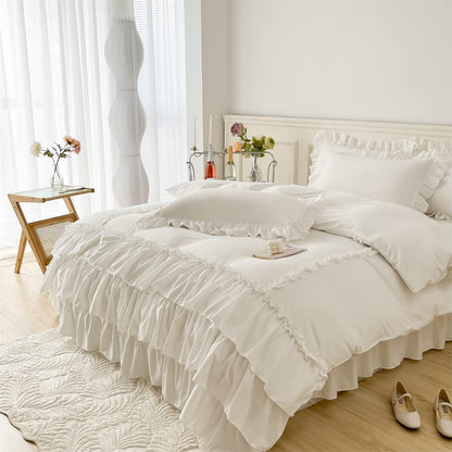 Neatly made bed with white ruffled bedding in a bright bedroom.