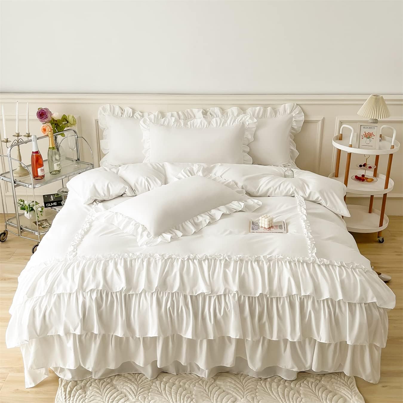 White ruffled bedding set on a bed in a bedroom setting.