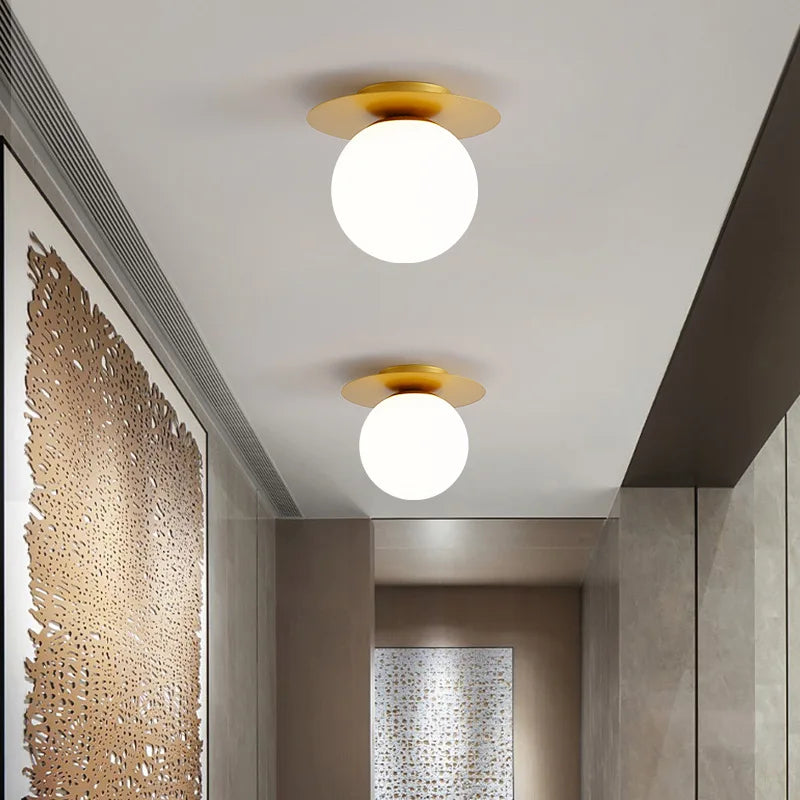 A pair of stylish white and gold light fixtures mounted on a wall, featuring the Luminova White Glow Ceiling Lamp.