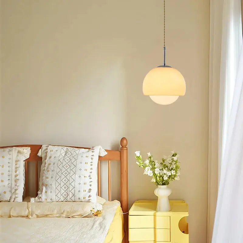 Sunny yellow bed with a white lamp hanging above, illuminated by Crystal Glow Pendant Lamp.