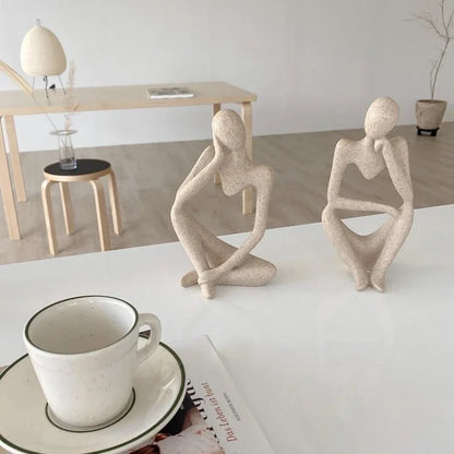 A sculpture of a pensive woman seated on a table, known as "The Thinker Statue Tabletop Art.