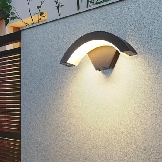 A sleek CurveGlow Outdoor Wall Light with a curved shape, adding a touch of elegance to the side of a building.