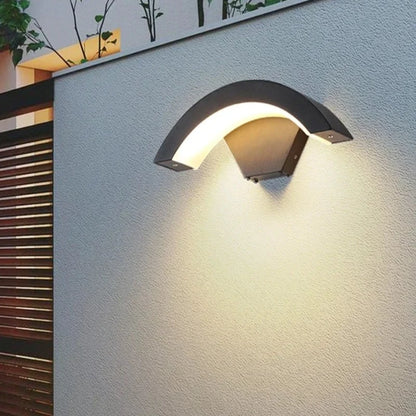 A sleek CurveGlow Outdoor Wall Light with a curved shape, adding a touch of elegance to the side of a building.